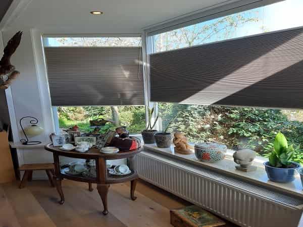 Plisse gordijnen kunnen op kunststof ramen worden gemonteerd met klemsteunen.