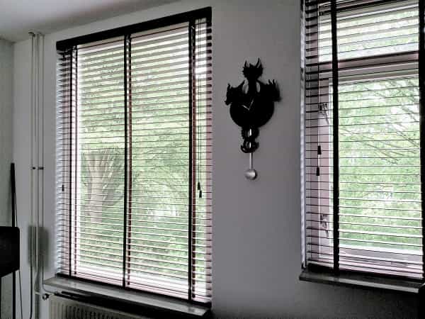 Houten jaloezieën kunnen als zwarte raamdecoratie veel warmte opnemen.